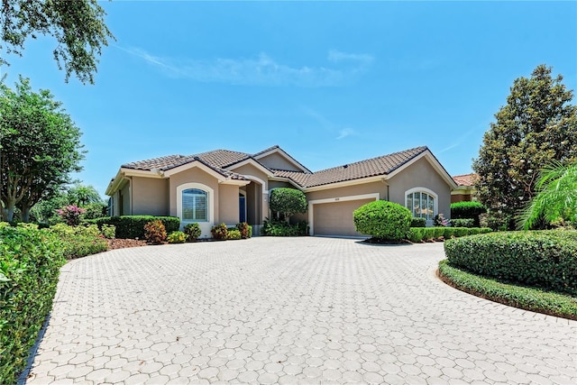 5205 88th St E, Bradenton, FL 34211 - view of front facade with stucco siding, a garage, curved driveway, and a tile roof