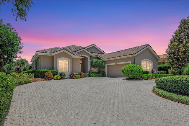 5205 88th St E, Bradenton, FL 34211 - view of front of house with curved driveway, stucco siding, a garage, and a tiled roof