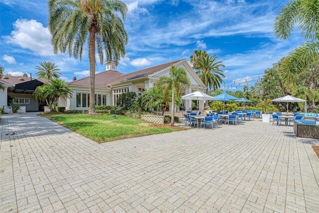 5205 88th St E, Bradenton, FL 34211 - view of front of house with outdoor dining space, a front yard, and a patio