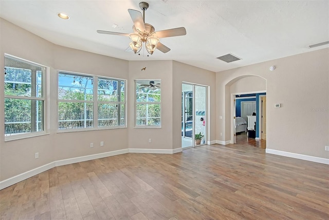 4603 4th Ave E, Bradenton, FL 34208 - empty room with wood finished floors, a ceiling fan, arched walkways, baseboards, and recessed lighting