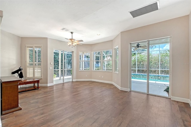 4603 4th Ave E, Bradenton, FL 34208 - unfurnished living room featuring a ceiling fan, plenty of natural light, baseboards, and wood finished floors