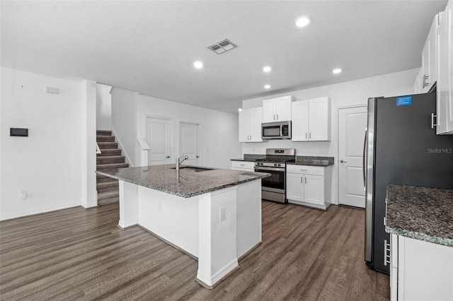 8656 40th Cir E, Palmetto, FL 34221 - kitchen with stainless steel appliances, dark wood-style flooring, a sink, white cabinets, and an island with sink