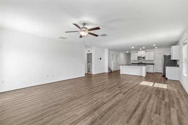 8656 40th Cir E, Palmetto, FL 34221 - unfurnished living room with wood finished floors, ceiling fan, recessed lighting, and baseboards
