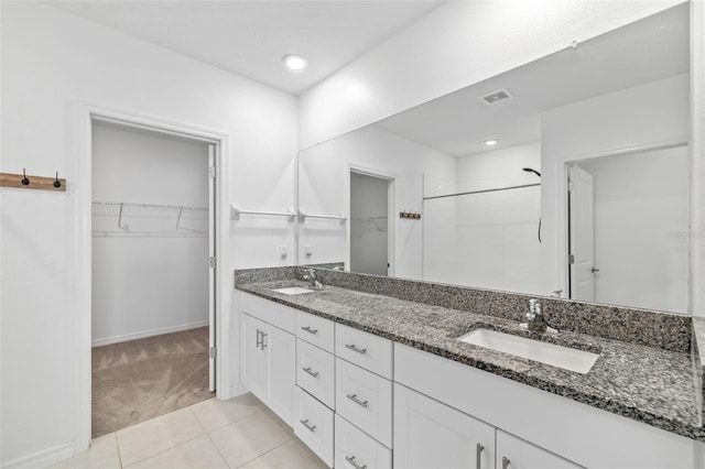 8656 40th Cir E, Palmetto, FL 34221 - bathroom featuring double vanity, a walk in closet, a stall shower, tile patterned flooring, and baseboards