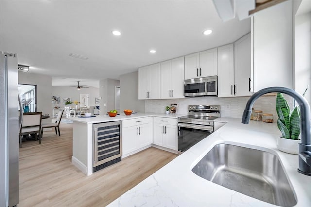 5125 Palm Aire Dr, Sarasota, FL 34243 - kitchen with wine cooler, stainless steel appliances, a sink, recessed lighting, and backsplash