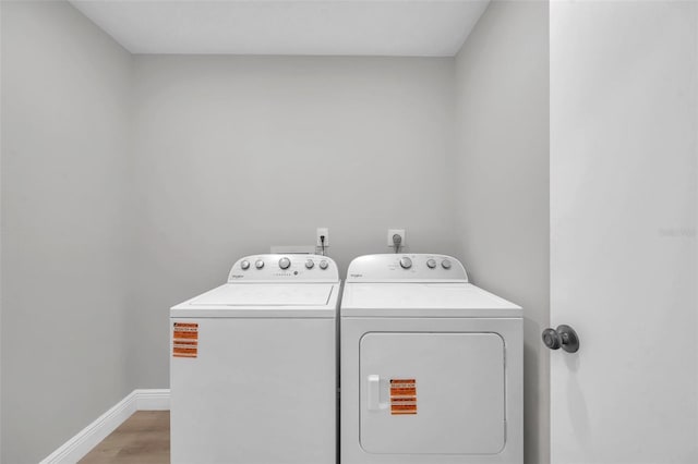 5125 Palm Aire Dr, Sarasota, FL 34243 - washroom with washer and clothes dryer, light wood finished floors, and baseboards