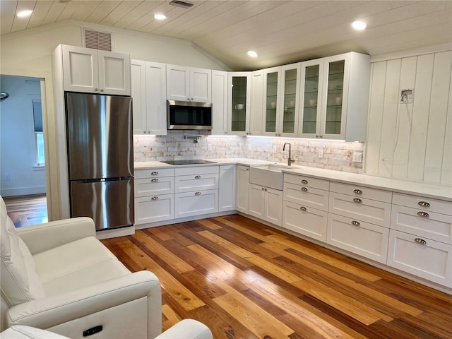 4412 125th St W, Cortez, FL 34215 - kitchen featuring stainless steel appliances, a sink, lofted ceiling, tasteful backsplash, and light countertops