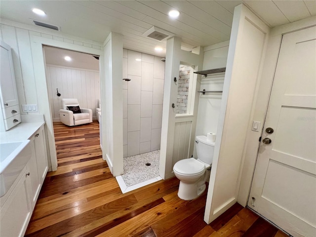 4412 125th St W, Cortez, FL 34215 - full bathroom featuring toilet, wood finished floors, tiled shower, vanity, and recessed lighting