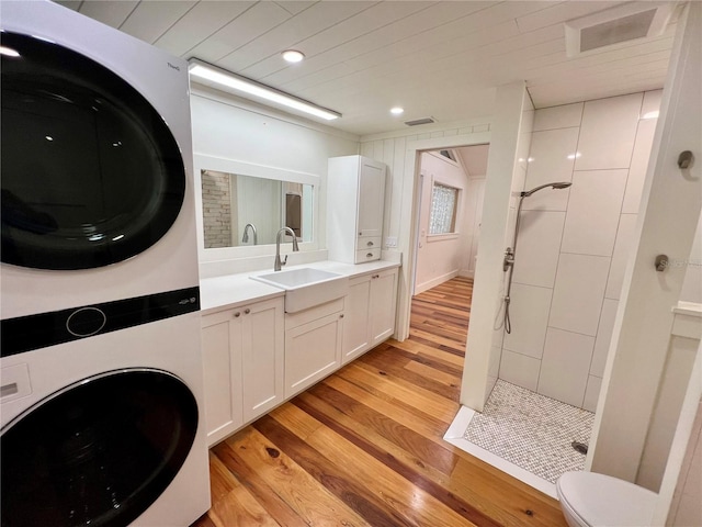 4412 125th St W, Cortez, FL 34215 - full bath with stacked washer / dryer, wood finished floors, a walk in shower, vanity, and toilet