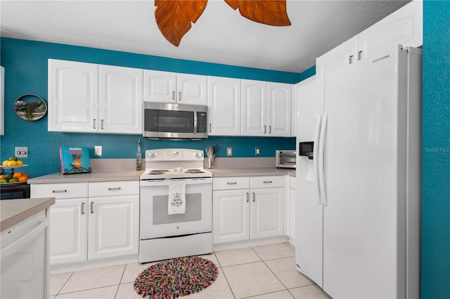 4222 Lanai Dr, Sarasota, FL 34241 - kitchen with white appliances, white cabinetry, light tile patterned flooring, and light countertops