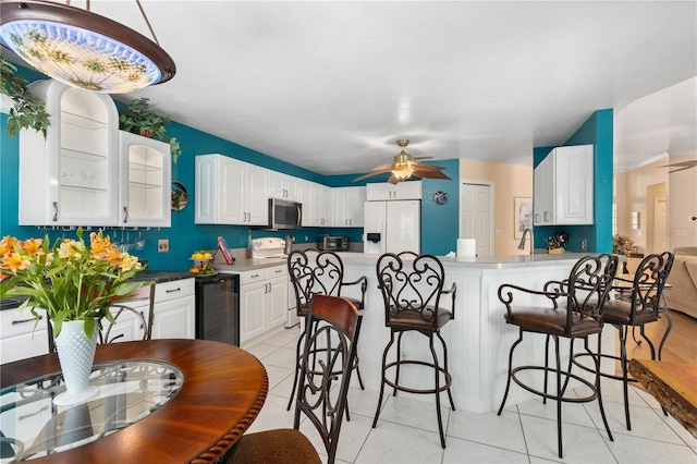 4222 Lanai Dr, Sarasota, FL 34241 - kitchen with stainless steel microwave, white fridge with ice dispenser, wine cooler, range with electric cooktop, and a breakfast bar
