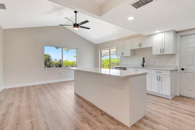 2420 16th St W, Palmetto, FL 34221 - kitchen with light wood finished floors, light countertops, a sink, a center island, and baseboards