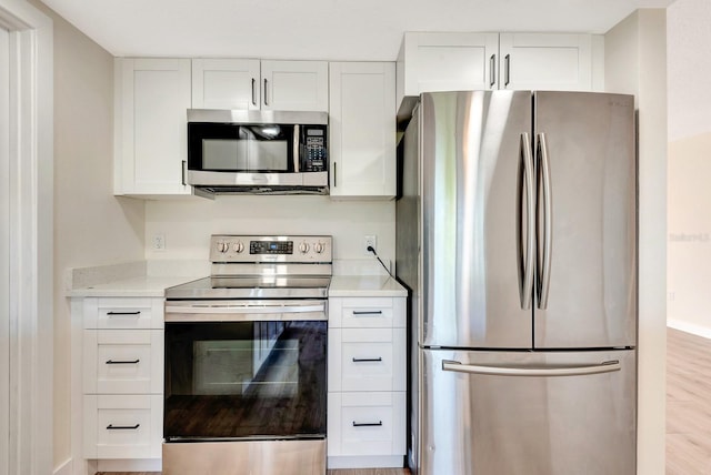 2420 16th St W, Palmetto, FL 34221 - kitchen featuring stainless steel appliances, white cabinetry, light countertops, and light wood-type flooring