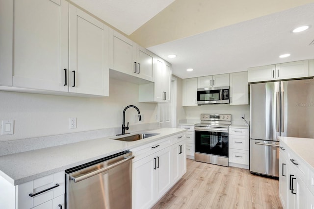2420 16th St W, Palmetto, FL 34221 - kitchen featuring stainless steel appliances, a sink, recessed lighting, light wood-style flooring, and white cabinets