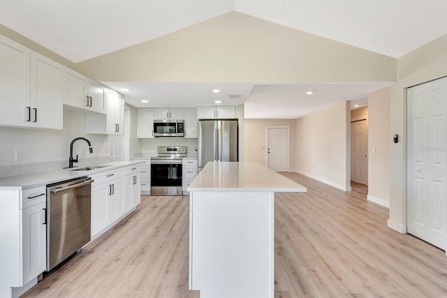 2420 16th St W, Palmetto, FL 34221 - kitchen with appliances with stainless steel finishes, a sink, vaulted ceiling, a kitchen island, and light wood-style floors