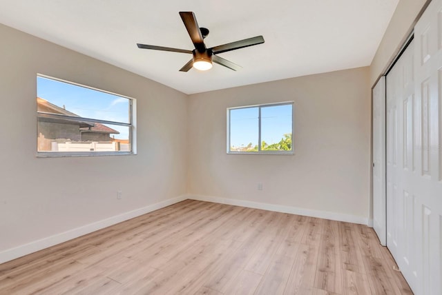 2420 16th St W, Palmetto, FL 34221 - unfurnished bedroom with a closet, wood finished floors, multiple windows, and baseboards