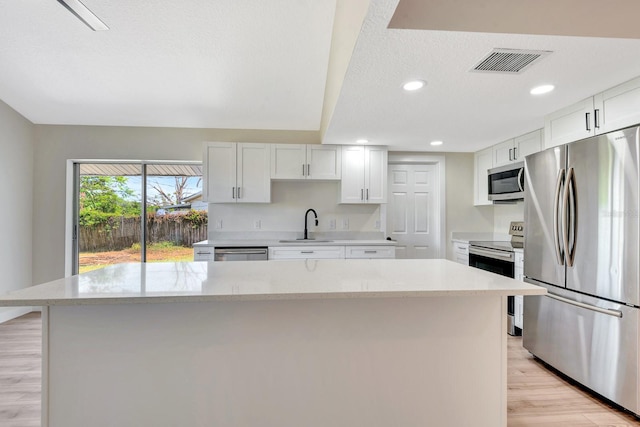 2420 16th St W, Palmetto, FL 34221 - kitchen featuring stainless steel appliances, light wood-style floors, a kitchen island, a sink, and recessed lighting