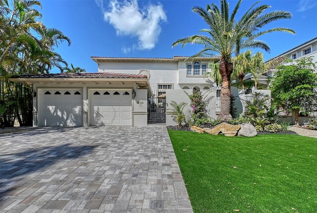 4108 Roberts Point Rd, Sarasota, FL 34242 - mediterranean / spanish-style home with a tile roof, stucco siding, decorative driveway, an attached garage, and a gate