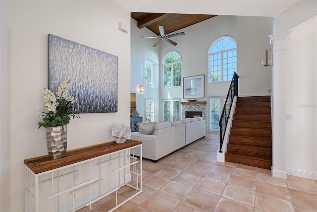 4108 Roberts Point Rd, Sarasota, FL 34242 - living room with high vaulted ceiling, ceiling fan, wood ceiling with exposed beams, stairway, and a lit fireplace