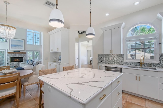 4108 Roberts Point Rd, Sarasota, FL 34242 - kitchen with a sink, backsplash, dishwasher, a center island, and white cabinetry