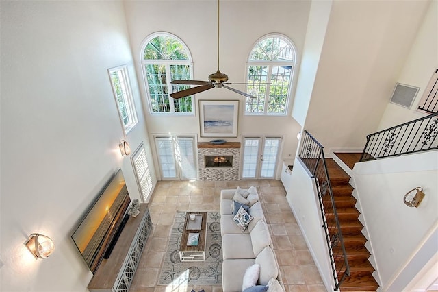 4108 Roberts Point Rd, Sarasota, FL 34242 - living area with a high ceiling, a lit fireplace, plenty of natural light, stairs, and a ceiling fan