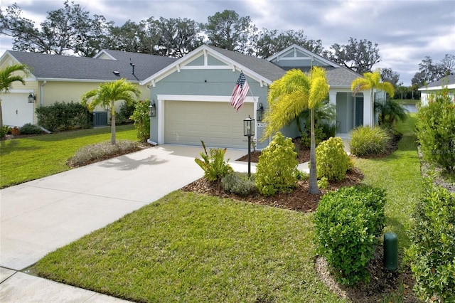3631 Shimmering Oaks Dr, Parrish, FL 34219 - view of front facade with concrete driveway, an attached garage, a front lawn, central AC, and stucco siding