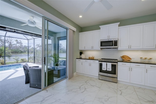 3631 Shimmering Oaks Dr, Parrish, FL 34219 - kitchen featuring stainless steel appliances, a ceiling fan, recessed lighting, a water view, and light marble finish floors