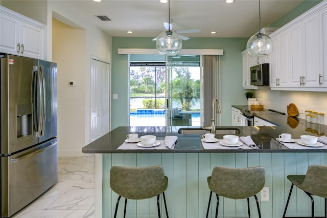 3631 Shimmering Oaks Dr, Parrish, FL 34219 - kitchen featuring appliances with stainless steel finishes, a sink, recessed lighting, white cabinets, and light marble finish floors
