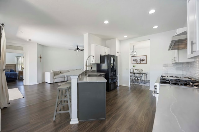 5020 Torrey Pines Run, Bradenton, FL 34211 - kitchen with stainless steel range with gas cooktop, wall chimney exhaust hood, black refrigerator with ice dispenser, a sink, and open floor plan