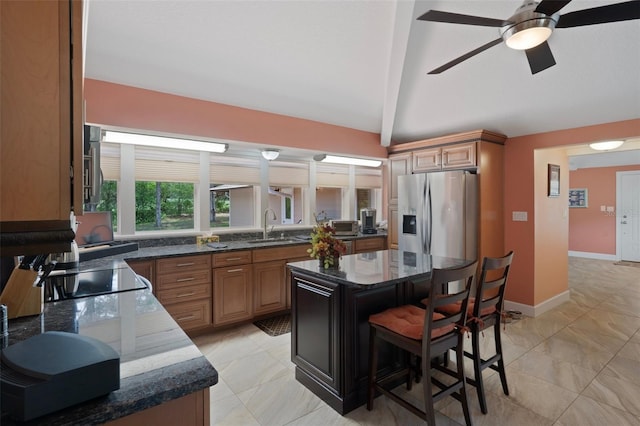 22063 Lake Lindsey Rd, Brooksville, FL 34601 - kitchen featuring stainless steel refrigerator with ice dispenser, a sink, lofted ceiling, dark stone countertops, and a ceiling fan