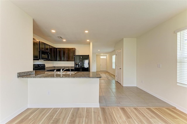 4206 Park Willow Ave, Palmetto, FL 34221 - kitchen with black appliances, a sink, dark brown cabinets, dark stone countertops, and recessed lighting