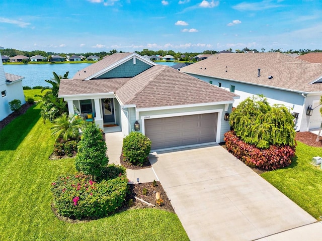 13849 Old Creek Ct, Parrish, FL 34219 - view of front of house featuring a shingled roof, an attached garage, a front yard, driveway, and a water view