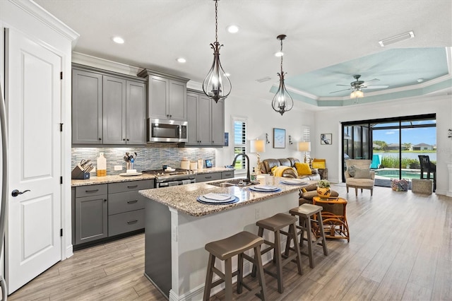 13849 Old Creek Ct, Parrish, FL 34219 - kitchen with stainless steel appliances, a sink, gray cabinetry, crown molding, and ceiling fan