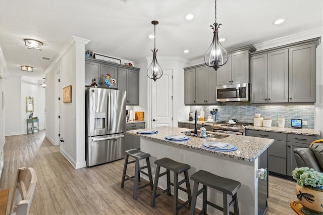 13849 Old Creek Ct, Parrish, FL 34219 - kitchen with stainless steel appliances, backsplash, ornamental molding, gray cabinets, and a kitchen island with sink