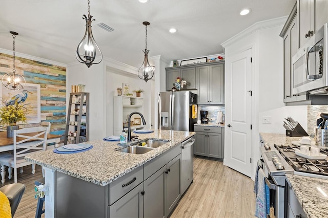 13849 Old Creek Ct, Parrish, FL 34219 - kitchen featuring appliances with stainless steel finishes, a sink, gray cabinetry, light wood-type flooring, and light stone countertops