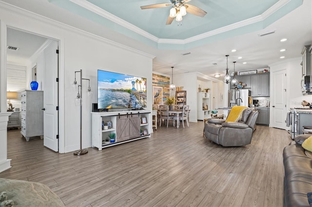 13849 Old Creek Ct, Parrish, FL 34219 - living area with ceiling fan, light wood-type flooring, recessed lighting, a tray ceiling, and ornamental molding