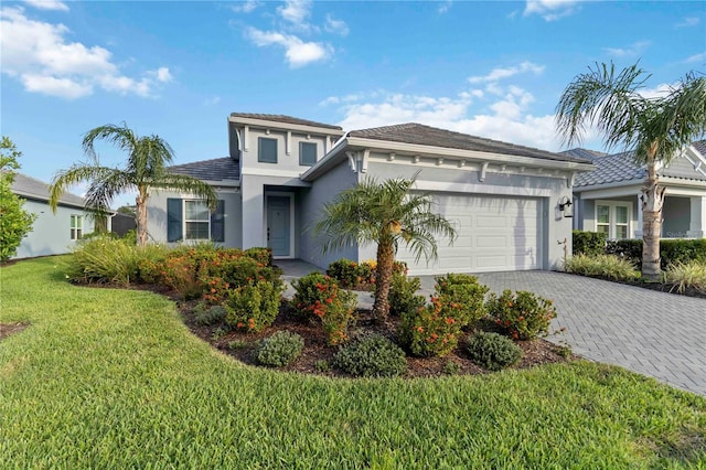 2794 Butterfly Jasmine Trl, Sarasota, FL 34240 - view of front of property with stucco siding, an attached garage, decorative driveway, and a front lawn