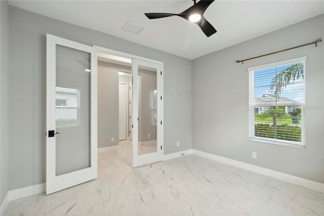2794 Butterfly Jasmine Trl, Sarasota, FL 34240 - unfurnished bedroom featuring marble look tiles, french doors, and baseboards