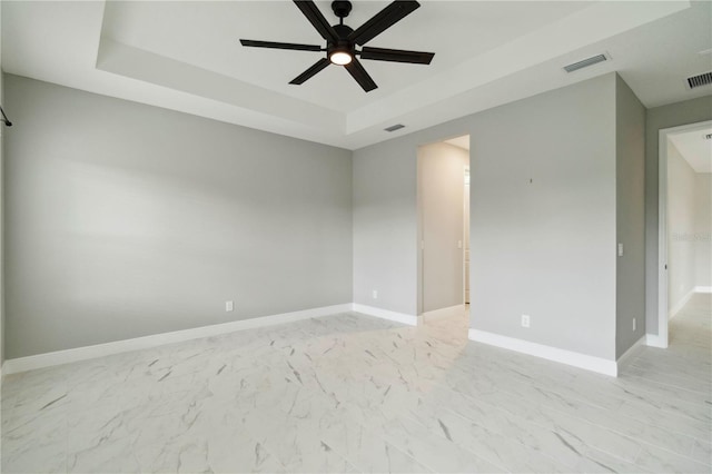 2794 Butterfly Jasmine Trl, Sarasota, FL 34240 - empty room featuring a raised ceiling, a ceiling fan, baseboards, and light marble finish flooring