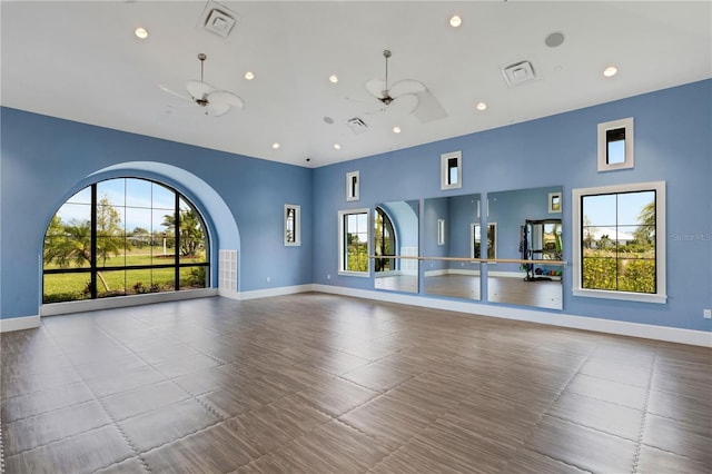 2794 Butterfly Jasmine Trl, Sarasota, FL 34240 - unfurnished living room featuring ceiling fan, baseboards, recessed lighting, and a towering ceiling