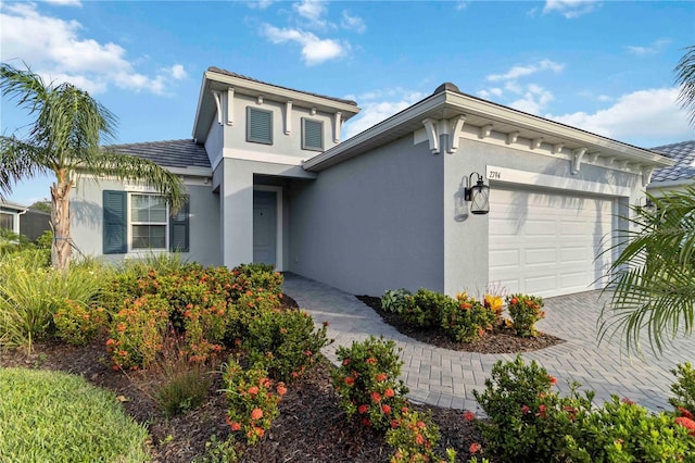 2794 Butterfly Jasmine Trl, Sarasota, FL 34240 - view of front facade featuring stucco siding, an attached garage, and driveway