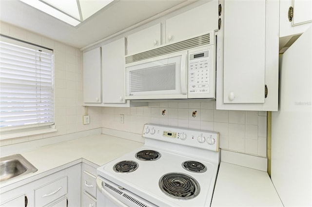 6030 7th Ave W Unit 6030, Bradenton, FL 34209 - kitchen featuring white appliances, light countertops, decorative backsplash, and white cabinets