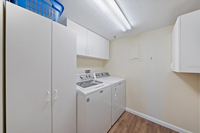 4570 Pinebrook Cir Unit 508, Bradenton, FL 34209 - laundry room featuring cabinet space, light wood finished floors, baseboards, washer and dryer, and a textured ceiling