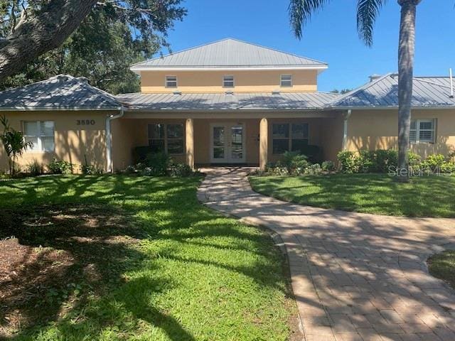4570 Pinebrook Cir Unit 508, Bradenton, FL 34209 - view of front facade with stucco siding, a standing seam roof, and a front lawn