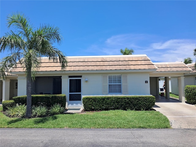6150 Midnight Pass Rd Unit V4, Sarasota, FL 34242 - view of front of house with concrete driveway, an attached carport, mansard roof, and a front yard