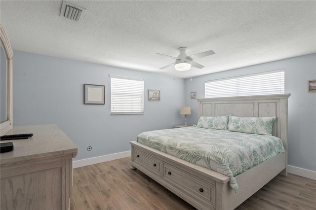 6150 Midnight Pass Rd Unit V4, Sarasota, FL 34242 - bedroom with baseboards, wood finished floors, a textured ceiling, and a ceiling fan