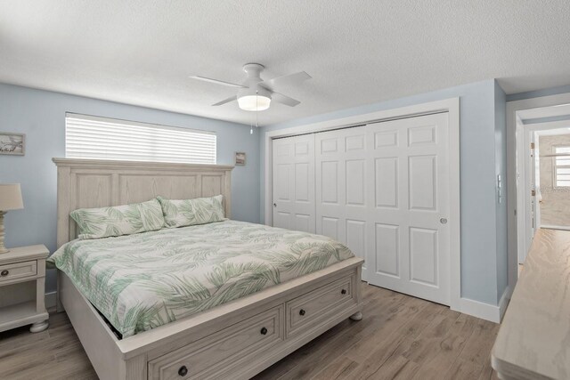 6150 Midnight Pass Rd Unit V4, Sarasota, FL 34242 - bedroom featuring light wood-style flooring, a closet, a textured ceiling, a ceiling fan, and baseboards