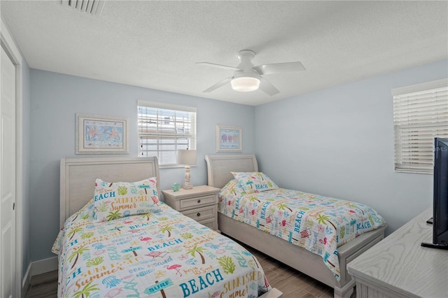 6150 Midnight Pass Rd Unit V4, Sarasota, FL 34242 - bedroom with wood finished floors, a textured ceiling, and ceiling fan