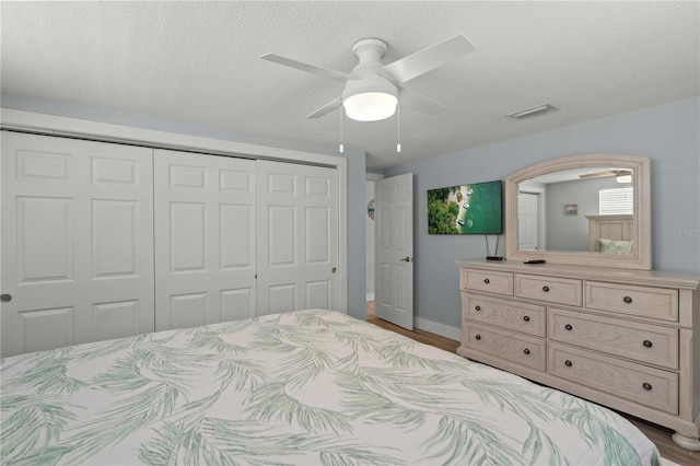 6150 Midnight Pass Rd Unit V4, Sarasota, FL 34242 - bedroom featuring a closet, wood finished floors, a ceiling fan, baseboards, and a textured ceiling