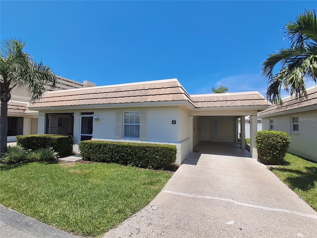 6150 Midnight Pass Rd Unit V4, Sarasota, FL 34242 - view of front facade featuring a front lawn, a carport, mansard roof, driveway, and a tiled roof